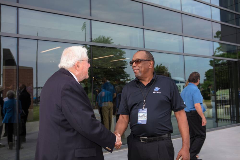 President Emeritus Don Lubbers shaking hands with a guest at the Jamie Hosford Football Center dedication.